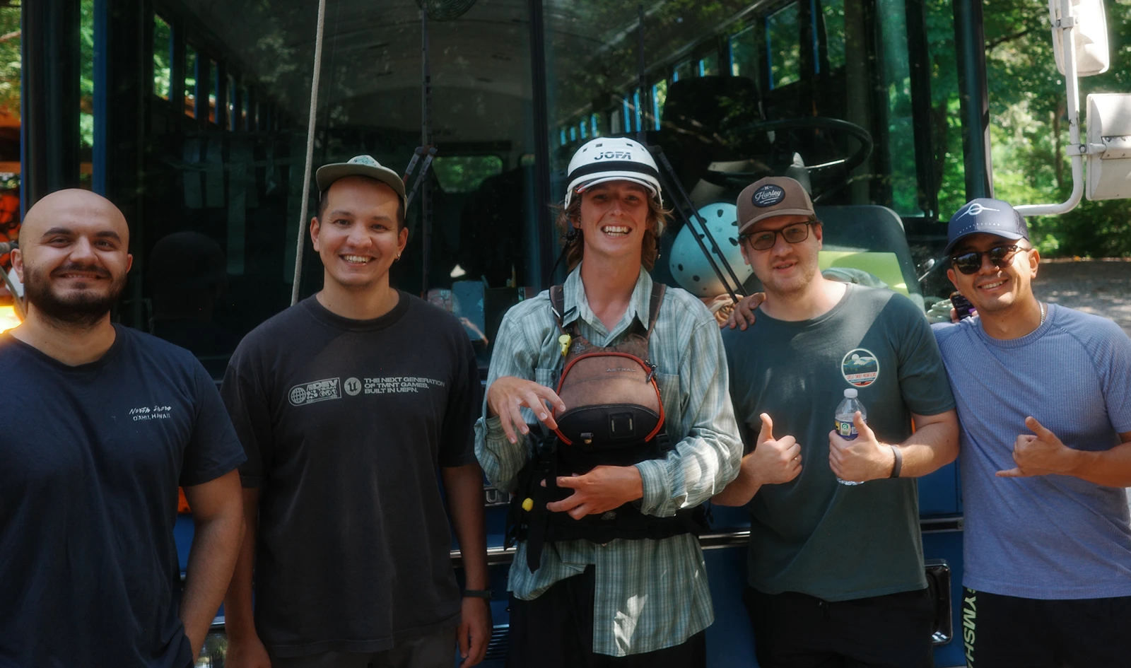 Group photo outdoors beside a bus